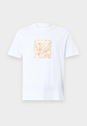 Balta medvilninė marškinė, puošti kvadratiniu béžiniu grafiniu raštu centre su tekstūrine danga. Trumpomis rankovėmis ir apvalia iškirpte.