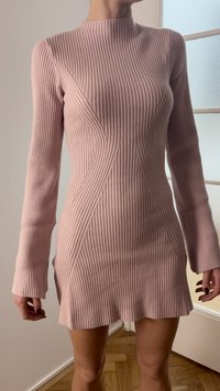 Ribbstickad klänning i mjuk rosa med långa ärmar, som har diagonala sömmar och sidospjäll för en figurnära siluett.