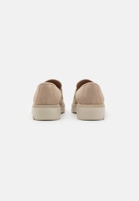 Beige suède schoenen met een laag profiel, ronde vorm en textuur rubberen zolen. Verstevigde stiksels aan de achterkant voor duurzaamheid.