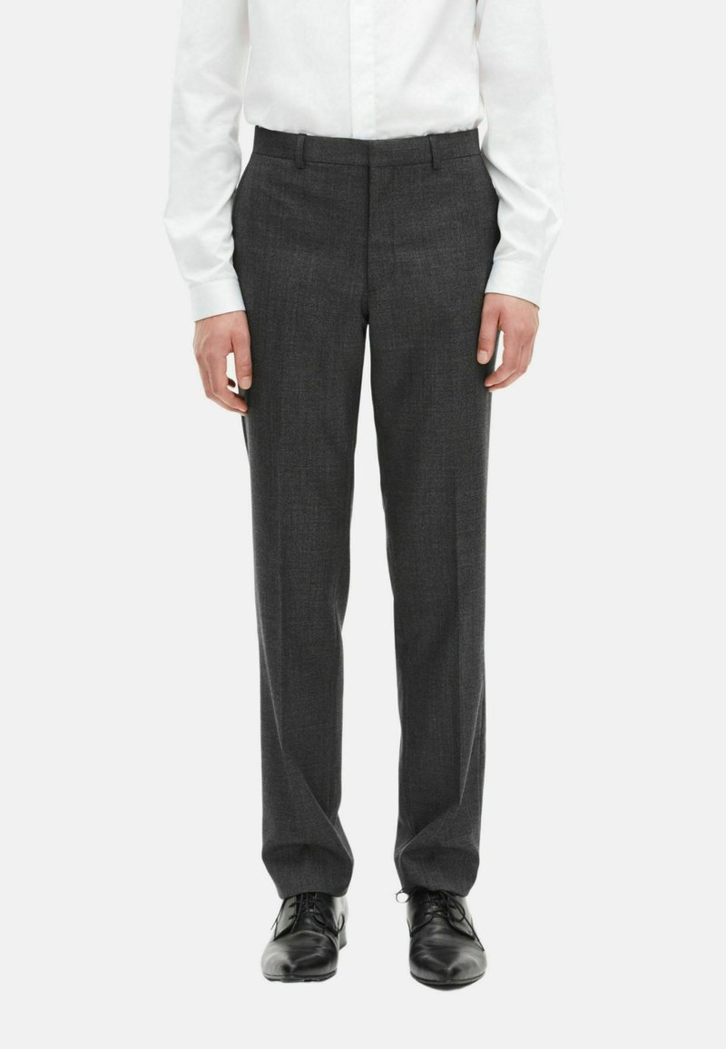 Grijze dresspantalons van gladde stof, met een slim fit, voorzien van een platte voorkant en een tailleband met riemlussen, gecombineerd met zwarte schoenen.