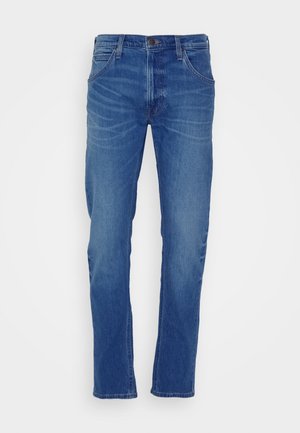 Jeans i medium blå med rett ben, fem lommer, beltehemper og et subtilt falmønster på forsiden.