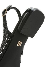 Sandalo con zeppa nera, superiore intrecciato, fascetta lucida e suola in gomma testurizzata. Presenta un'emblema dorato sul lato.