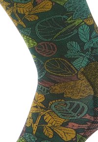 Calzini verdi con un motivo a foglia in giallo, arancione e teal. Realizzati in un tessuto testurizzato con un bordo rigato per una maggiore elasticità.