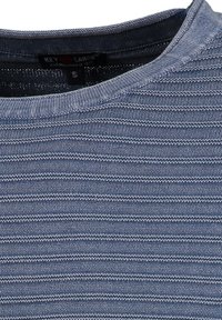 Camisa de punto a rayas azules con cuello redondo, hecha de una tela suave con rayas verticales y horizontales de diferentes anchos.