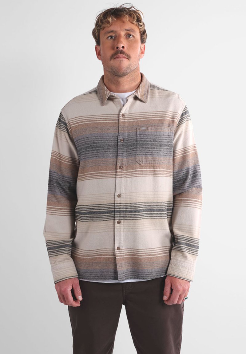 Camicia a maniche lunghe a quadri in beige, marrone e grigio, con chiusura a bottoni e tasca sul petto. Realizzata in un materiale morbido e testurizzato.