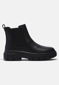 Bottine noire en cuir montant à la cheville avec semelle épaisse à crampons, panneaux latéraux élastiques, languette de tirage et logo embossé au talon.
