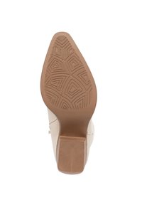 Zapato de tacón alto beige con suela de goma texturizada, que presenta un patrón geométrico, punta ligeramente afilada y un tacón cuadrado de altura media.