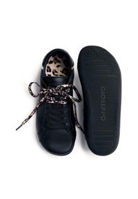 Zapatilla negra de piel con interior de estampado de leopardo y cordones a juego. La suela exterior presenta una superficie texturizada con detalles del logotipo.