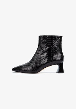 Bottines noires en matériau glossy, avec une texture serpent, un bout pointu et un talon bloc de forme géométrique.