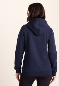 Navy blue hooded sweatshirt with ribbed cuffs and hem. Soft texture, medium thickness, featuring a kangaroo pocket and detailed stitching.