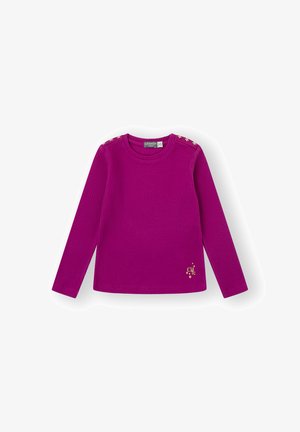 Suéter de manga larga, de canalé en magenta brillante con acentos de estrellas doradas en los hombros y un pequeño emblema dorado en el dobladillo. Textura de tela suave.