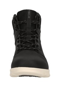 Scarpa da trekking nera con tomaia in rete, linguetta in pizzo, dettagli testurizzati e suola bianca a contrasto. Presenta occhielli rinforzati e colletto imbottito.