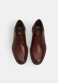Chaussures habillées en cuir marron, avec une texture lisse, un bout arrondi et un design à bout lisse. Elles sont dotées de lacets et d'une semelle moulée.