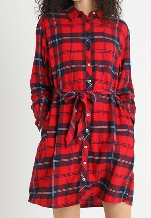 Rot- und marineblau kariertes Hemdkleid mit durchgehender Knopfleiste, langen Ärmeln und tailliertem Gürtel. Hergestellt aus weichem Stoff mit bequemer Passform.