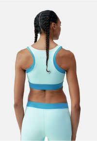 Sutien sport de culoare albastră deschisă, cu accente de albastru mai închis. Design elegant, realizat dintr-un material moale și elastic, cu spate tip racerback. Fără modele vizibile.
