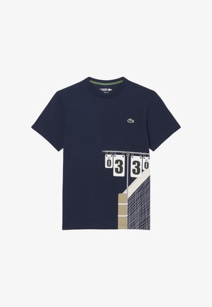 Camiseta azul marino con el logo de Lacoste y un gráfico de una red de tenis y un marcador que muestra los puntos del set 0, 3 y 0.