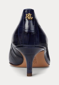 Navy patent leather high heel shoe with a crocodile texture, featuring a gold logo accent on the back and a slender heel.