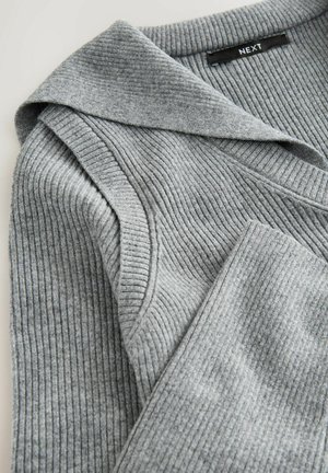 Pilkas raukšlėtas megztinis su plačiu apykakle ir sulenktais akcentais. Audinio tekstūra yra minkšta, su nuolatine vertikalių raukšlių raštu. Matomas prekės ženklas.