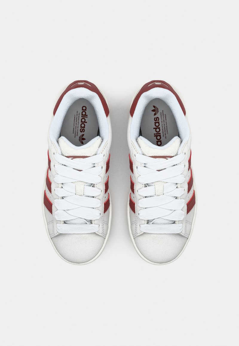 Weiße Sneakers mit roten Streifen, ausgestattet mit einem strukturierten Lederoberteil, flachen Schnürsenkeln und einem gepolsterten Kragen. Signatur-Logo auf der Zunge.