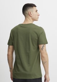 Oliven grønn bomulls t-skjorte med korte ermer, rund hals og en jevn tekstur. Har en avslappet passform og minimalistisk design uten synlige logoer.