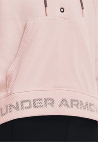 Sudadera rosa claro con un bolsillo de malla y cordón con detalles en negro; logo "UNDER ARMOUR" impreso en negro a lo largo del dobladillo.