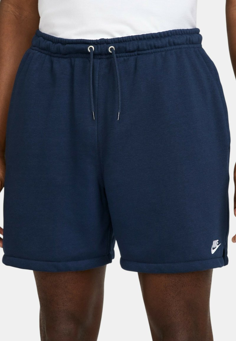 Shorts bleu marine en mélange de coton doux, avec une taille élastique à cordon de serrage et le logo Nike sur la jambe inférieure.