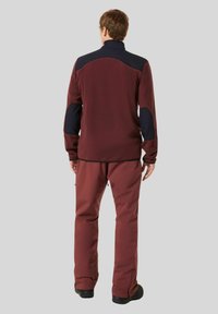 Maroon fleece jacket with navy accents and high collar, paired with matching maroon pants, shown from the back against a gray background.