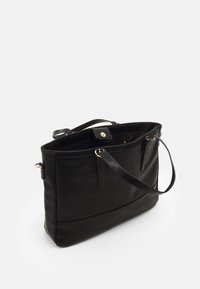 Bolso tote de cuero negro con una forma estructurada, textura suave y acentos de hardware dorado. Presenta dos asas y un cierre magnético.