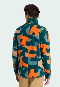 Fleece-Pullover, mehrfarbiges geometrisches Muster in Türkis, Orange und Beige, hoher Kragen, weicher Stoff, lange Ärmel, lockere Passform.