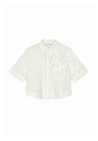 Valkoinen lyhythihainen crop-top, joka on valmistettu pitsikankaasta ja jossa on monimutkaisia kukkakuoseja sekä yksi rintatasku. Napillinen etuosa.
