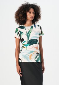 T-paita lyhyillä hihoilla, jossa on monivärinen kukka- ja lehtikuvio vaalealla taustalla, valmistettu pehmeästä kankaasta, yhdistetty mustaan hameeseen.