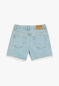 Pantalones cortos de denim azul claro con el dobladillo deshilachado, dos bolsillos traseros y una etiqueta de cuero marrón en la cintura. Diseño clásico de cinco bolsillos.
