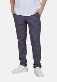 Slim-fit dunkelgraue Pants aus einem Baumwoll-Mischgewebe, mit Seitentaschen und glatter Textur, kombiniert mit weißen Sneakers.