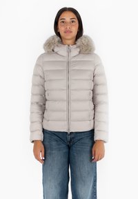 Lichtgrijze pufferjack met een met bont gevoerde kap, horizontale geweven textuur, ritssluiting aan de voorkant en zijzakken. Gecombineerd met losse denim jeans.
