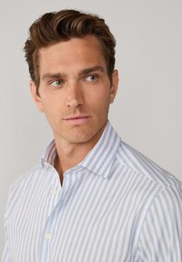 Lichtblauw en wit gestreept overhemd, gemaakt van gladde stof, met een knoopsluiting bij de kraag, zichtbare knopen en een getailleerd ontwerp.