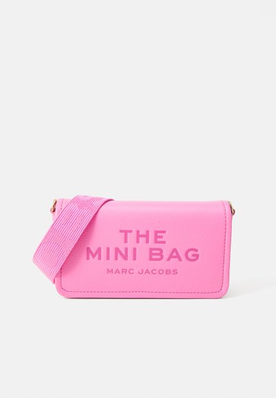 Pink leather mini bag with a textured surface, featuring a wide strap and embossed text, "THE MINI BAG MARC JACOBS" on the front.