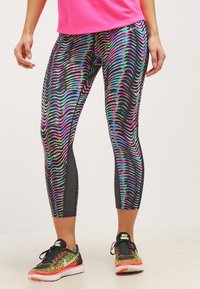 Wielokolorowe legginsy sportowe z falistym wzorem w różowym, niebieskim i zielonym kolorze na czarnym tle. Charakteryzują się skróconą długością i elastycznym materiałem.