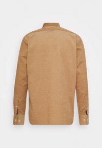 Camicia in velluto a coste marrone con colletto button-down e maniche lunghe. Presenta bottoni sui polsini e una finitura morbida e testurizzata.