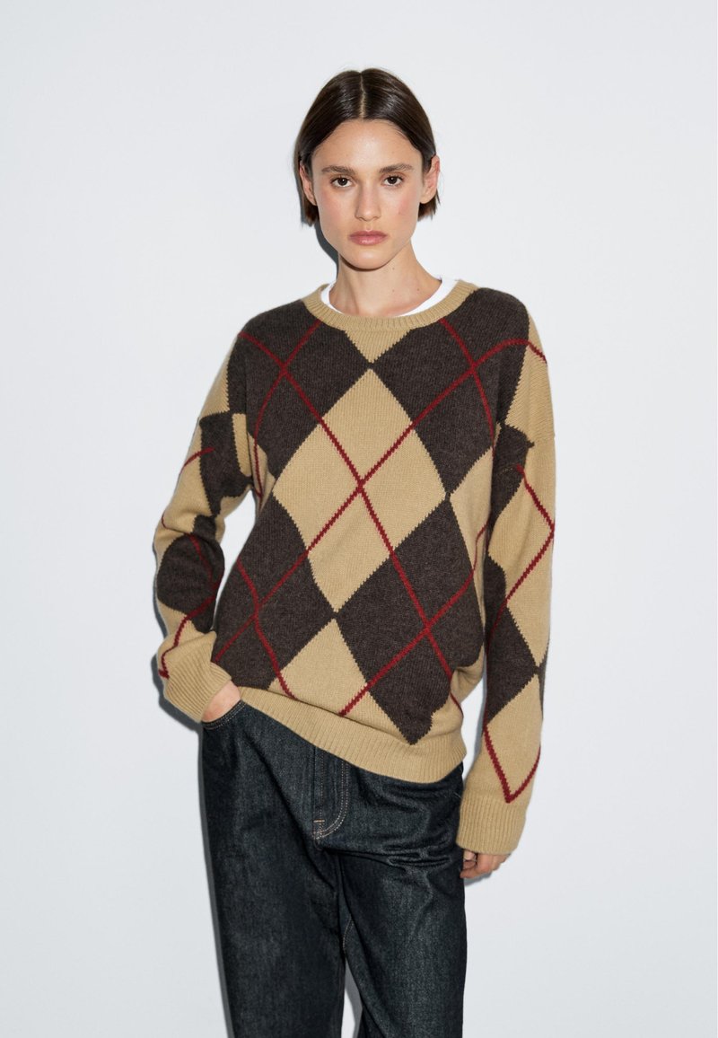 Strickpullover mit einem braun-beigen Argyle-Muster und roten Akzenten. Rundhalsausschnitt, lange Ärmel und lässige Passform. Strukturierter Stoff.