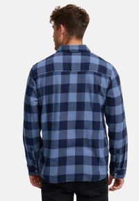 Geruit langemouwen overhemd in blauw en marine, van katoen, met knoopmanchetten en klassieke kraag; zichtbare stiksels op de achterkant.