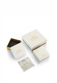 Ensemble de boîtes à bijoux blanches avec des accents dorés, de différentes tailles et formes. Comprend une boîte carrée et une note sur du papier recyclé.