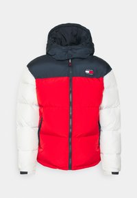 Chaqueta acolchada con capucha desmontable; secciones rojas y blancas con parte superior azul marino, cremallera frontal y logo en el pecho. Textura suave.