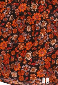 Bloemrok met een zwarte achtergrond, patroon van oranje en paarse bloemen, geplooid ontwerp en een klein merklabel aan de zoom.