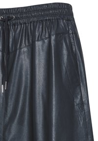 Mørkeblå lædershorts med elastisk talje og justerbar snor. Har sidelommer og en glat, skinnende overflade.