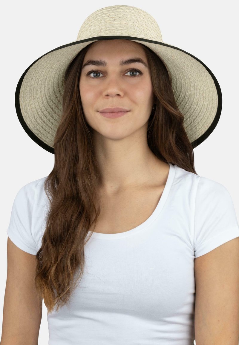 Breiter Strohhut mit einer natürlichen gewebten Textur, akzentuiert durch ein kontrastierendes schwarzes Band. Der Hut hat eine abgerundete Krone und eine entspannte Form.