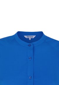 Blusa blu brillante con scollatura rotonda, chiusura a bottoni sul davanti e tessuto morbido e leggero. Etichetta con la scritta "Soft Rebels", taglia S.