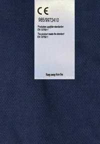 Navy fabric with a smooth texture featuring a white label. The label includes safety standards, a CE mark, and care instructions.