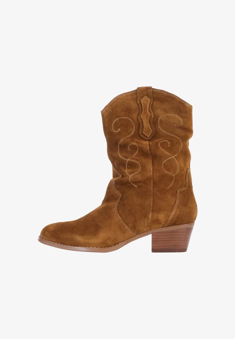Bottes de cowboy en daim marron avec une pointe arrondie, des coutures décoratives et un petit talon empilé. Elles possèdent une tige haute avec un bord festonné.