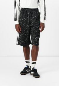 Pantaloni scurți negri cu un model de leopard, fabricați dintr-un material neted, având o talie elastică și trei dungi albe pe laterale.