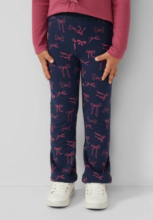 Leggings en coton navy avec des motifs de nœuds roses, offrant une coupe ajustée et une taille élastique. Associés à des baskets blanches et un haut côtelé rose.